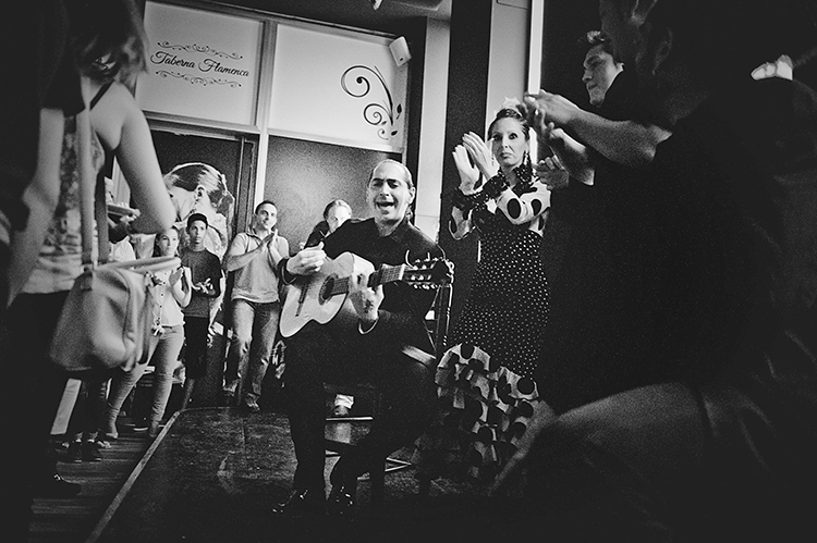 Fiesta flamenca con guitarra y palmas en la taberna, en blanco y negro